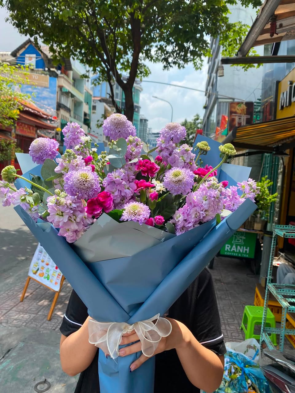 Bó hoa tím và hồng gói giấy xanh, buộc nơ trắng